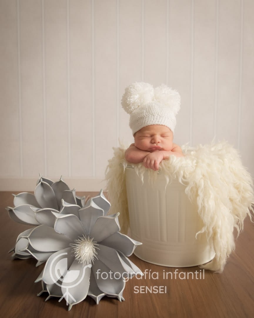 Sesión de bebé recién nacido en Salamanca a Rodrigo en un cubo y decoración floral .